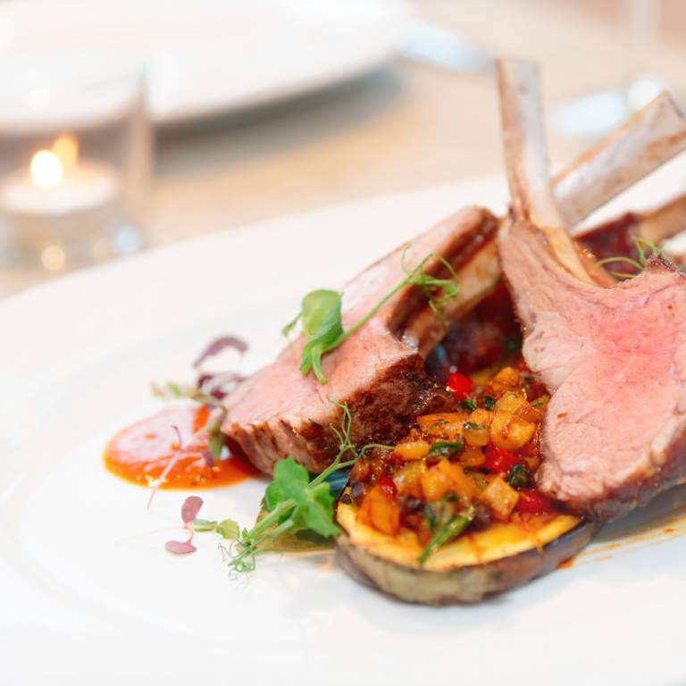 Grilled rack of lamb with vegetables on plate